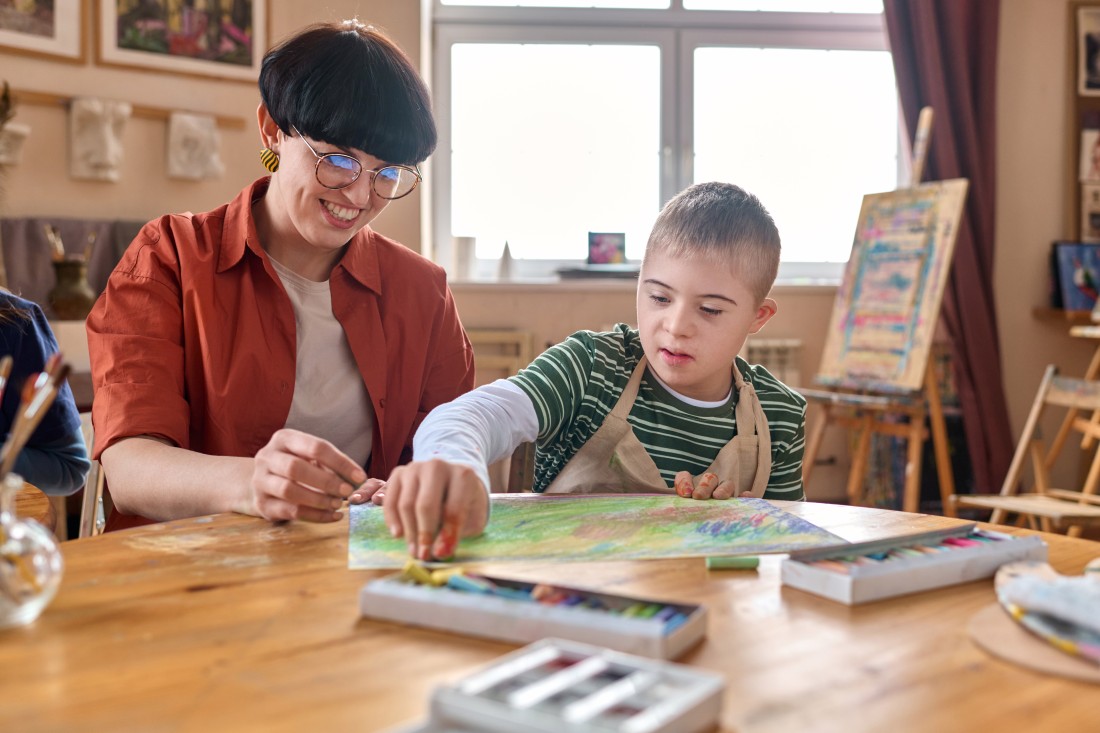  Disability Support For Children, Adults and Seniors - Calgary, AB | ComForCare - boy-with-down-syndrome-enjoying-art-class-with-tea-2024-04-09-17-37-31-utc